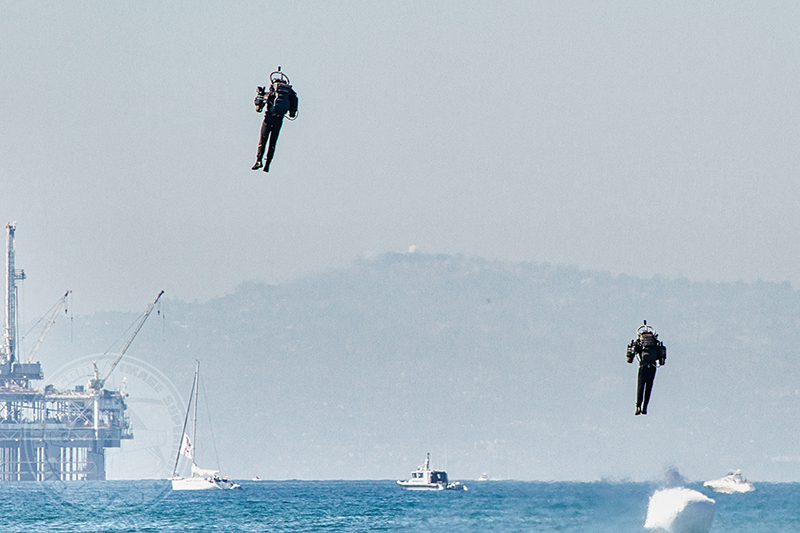 Jet pack pilots launched from the beach, over the water in first air show appearance. Photo: Luke Thow